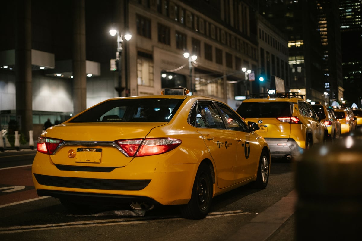 Yellow cabs driving along road at night